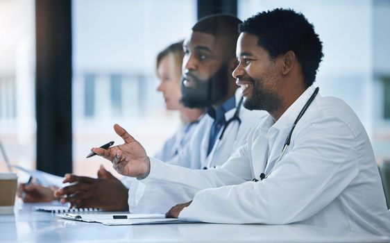 Doctor have discussion about medical document in a meeting together at work. Healthcare workers talking and planning, communication and strategy in a hospital office or boardroom.