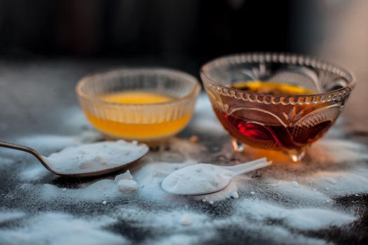 Baking soda face mask in a glass bowl on wooden surface along with baking soda powder and honey for Dark lips.Horizontal shot.