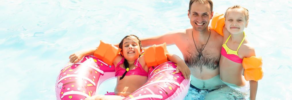 Children playing in pool. Two little girls having fun in the pool. Summer holidays and vacation concept.