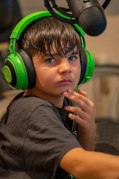 Child ready and well equipped to start gaming and live streaming at home in his room.