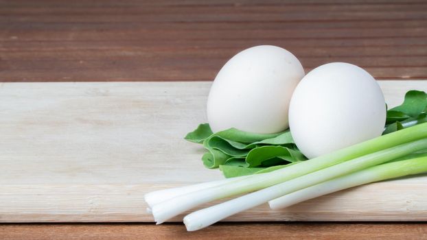 eggs, arugula and green onions feathers on a wooden cutting board background. High quality photo