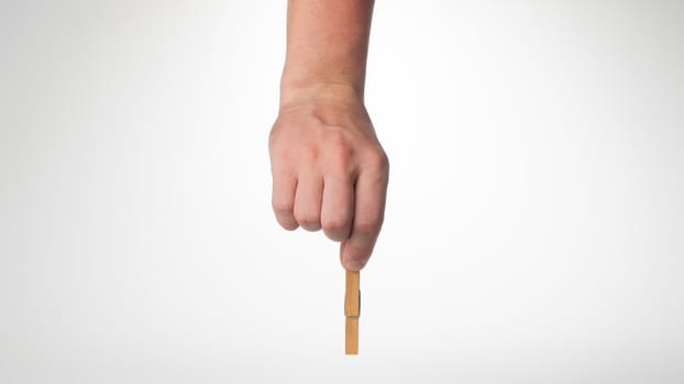 A man's hand holds a wooden gesture clothespin place for writing. High quality photo