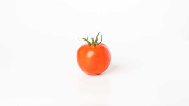 Tomato with a branch on a white background close-up vegetable. High quality photo