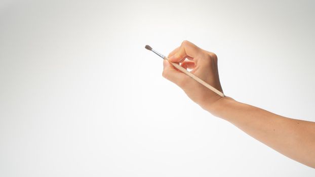Hand and brush for drawing on a white background, draws a right-hander. High quality photo