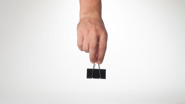 A man's hand on top holds a clip to clip paper space for text. High quality photo