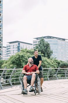 disabled man in wheelchair walks with his friend through the city, concept of friendship and integration of people with disabilities and reduced mobility problems, vertical photo