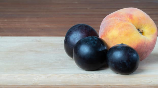 Peach and plum on a wooden board close-up of fruit. High quality photo