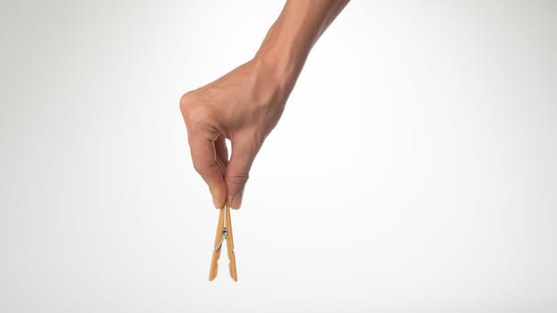 woman's hand holds an open wooden clothespin on top. High quality photo