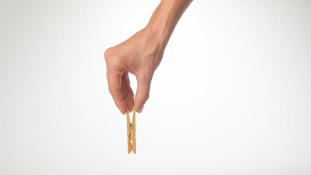 women's hand holds a wooden gesture clothespin place for writing. High quality photo