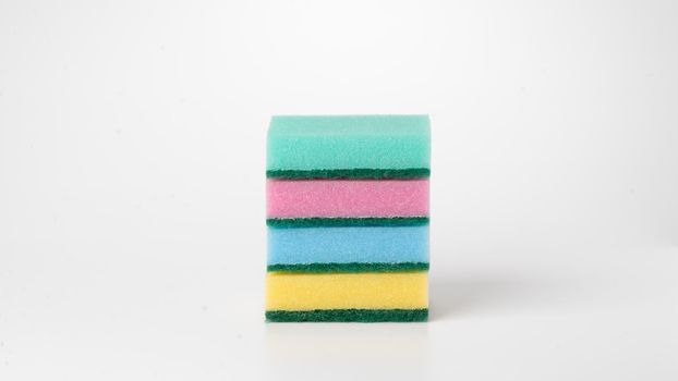 Multicolored four sponges folded into a flat stack on a white background. High quality photo