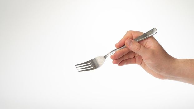Fork in the right male hand gesture to eat on a white background. High quality photo