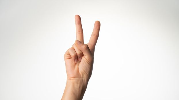 Women's hands gesture counting on fingers 2 palm side. High quality photo