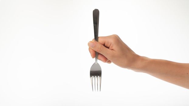 Fork in a woman's hand on a white background gesture to prick on a fork. High quality photo