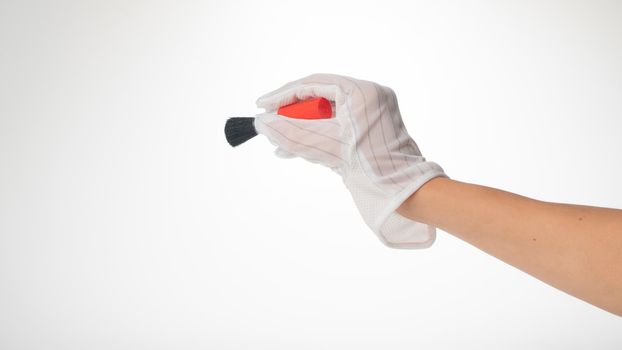 Hand in glove and brush gesture to remove dust on white background. High quality photo