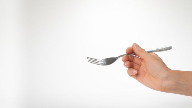 Fork in the right woman hand gesture to eat on a white background. High quality photo