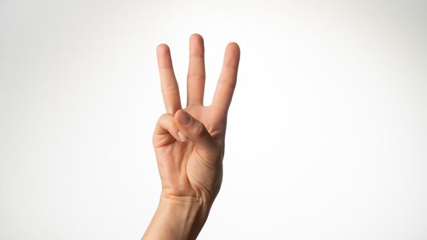 Women's hands gesture counting on fingers 3 palm side. High quality photo