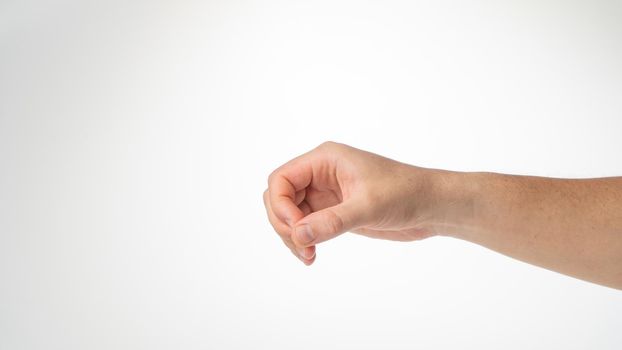 Hand male gesture fingers clenched into a ring holding a cylinder. High quality photo