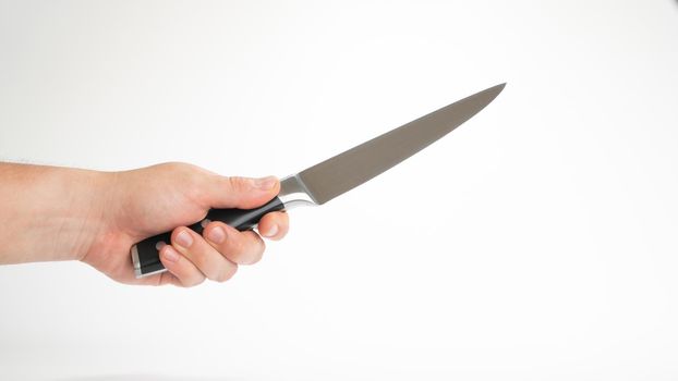 Kitchen knife in a man's hand, holds diagonally on a white background. High quality photo