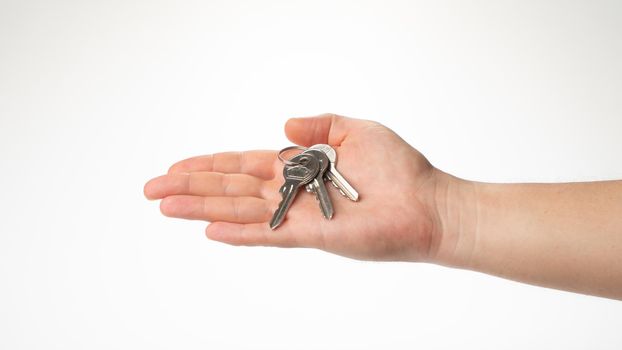 A bunch of keys lies on a man's right palm gesture. High quality photo