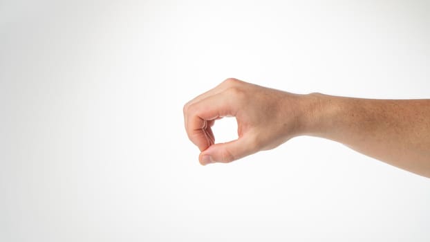 Hand male gesture fingers clenched into a ring holding a cylinder. High quality photo