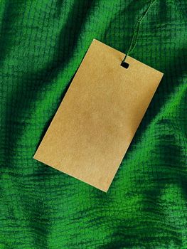 Blank fashion label tag, sale price card on luxury fabric background, shopping and retail concept