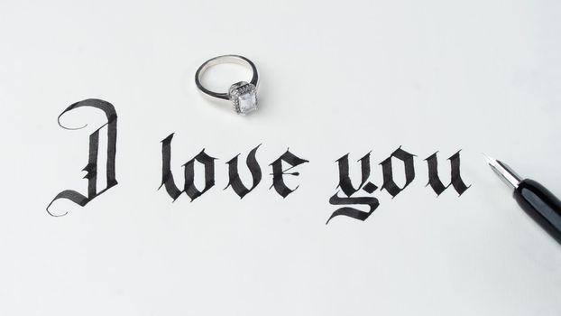 Calligraphy I love you with wedding ring and fountain pen. High quality photo