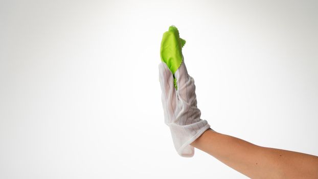 Hand in a clean glove with a green cloth for wiping screens side view requires the monitor. High quality photo