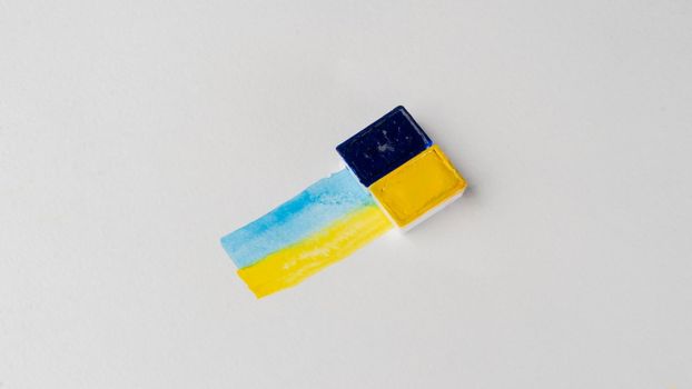 blue and yellow stripes of watercolor paint with paint ditches on a white background no war