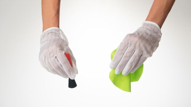 Gloved hands with a brush and a green cloth for cleaning equipment. High quality photo