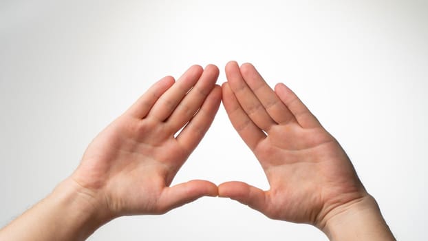 The man's palms are folded in a triangle on a white background. High quality photo