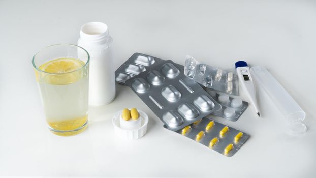 Medicines for treatment - tablets, pills, thermometer, water with lemon. High quality photo