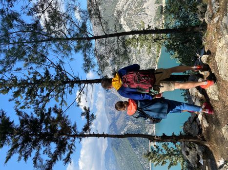 Man and woman travelers with backpacks on the top of the mountain look at the canyon, hiking. High quality photo