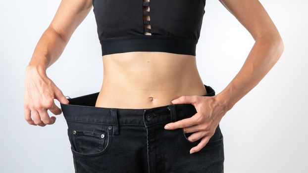 A woman in pants a size larger - weight loss, slim body, after dieting. High quality photo