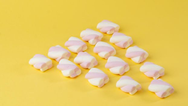 Background of marshmallow pigtails on a yellow background. High quality photo