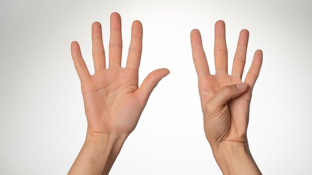 Women's hands gesture counting on fingers 9 palm side. High quality photo