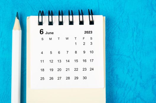June 2023 Monthly desk calendar for 2023 with pencil on blue background.