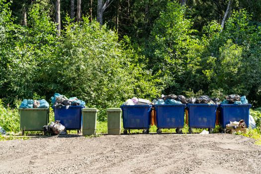 there are a lot of plastic garbage containers on the site filled with garbage and ready to be taken to the landfill