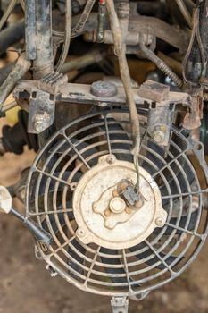 the front part of a broken and disassembled ATV in need of repair. cooling radiator, cooling fan. vertical photo