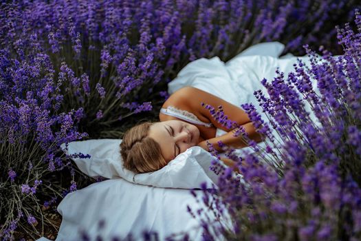 A middle-aged woman lies in a lavender field and enjoys aromatherapy. Aromatherapy concept, lavender oil, photo session in lavender.