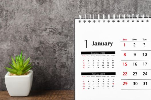 January 2023 Monthly desk calendar for 2023 on wooden background.