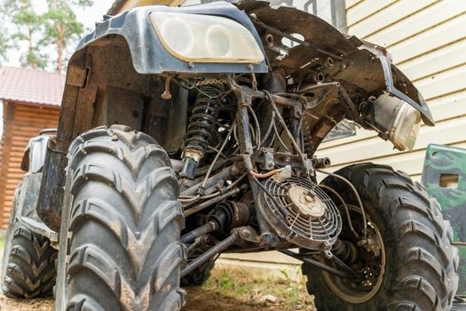 the front part of a broken and disassembled ATV in need of repair. cooling radiator, cooling fan