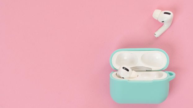 Wireless headphones and pink background case, text space. High quality photo