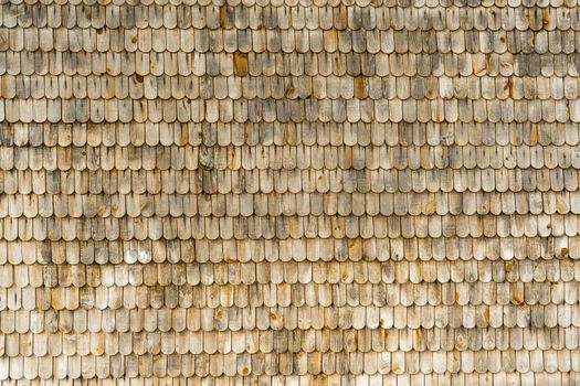 textured background of wooden tiles on the roof of an old house. natural material, wooden roof