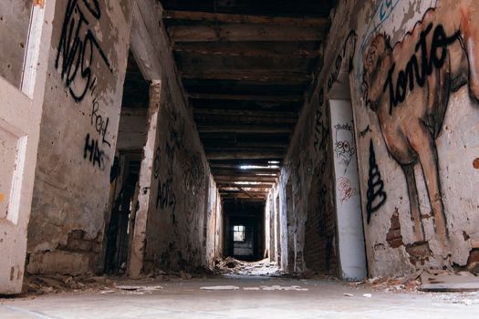 ruined abandoned hotel hallway with graffiti