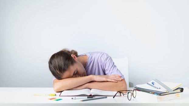 A tired student sleeps on a notebook on the table - before the exam. High quality photo