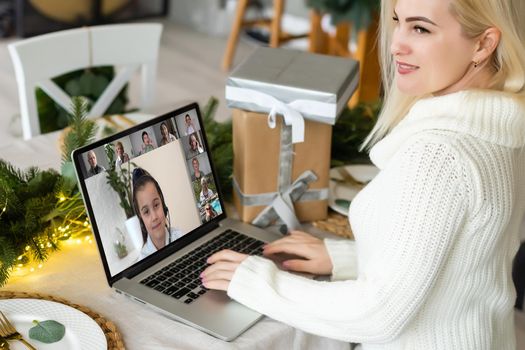 Virtual Christmas tree meeting team teleworking. Family video call remote conference. Laptop webcam screen view. Team meet working from their home offices. Happy hour party online woman.