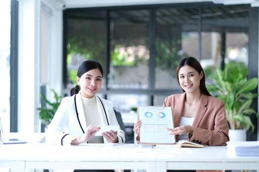 Two asian business woman work together to get the job done at the office..