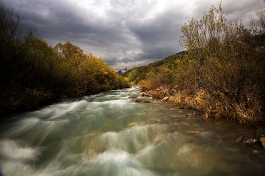 Wild river under a cloudy sky in long exposure picture in Spanish Pyrenees