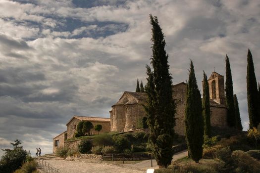 Romanesque church called Santa Maria de La Tossa and some trees under a cloudy sky