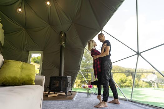a couple in geo dome tents. Cozy, camping, glamping, holiday, vacation lifestyle concept. Outdoors cabin, scenic background